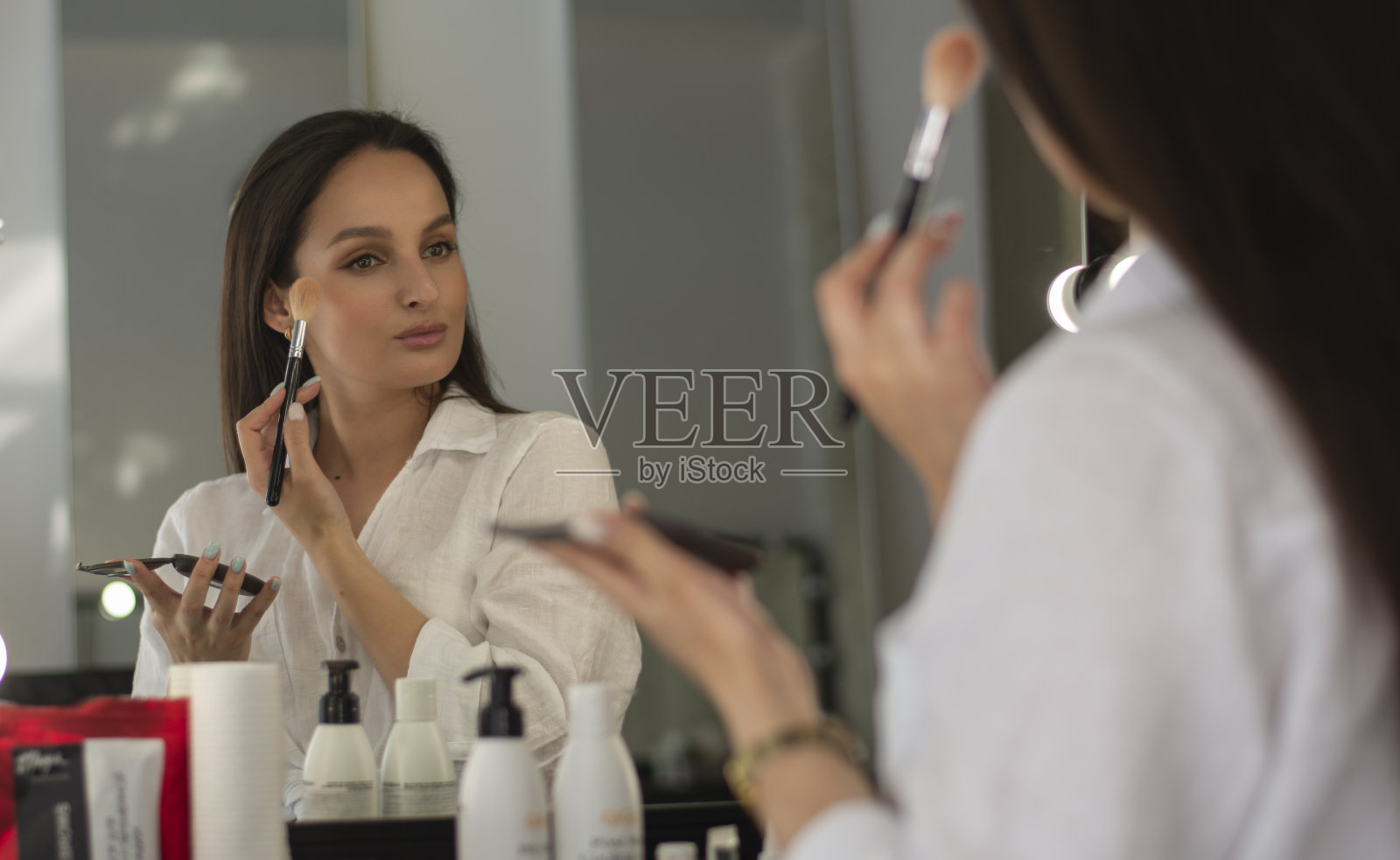 女孩在镜子里自己化妆照片摄影图片