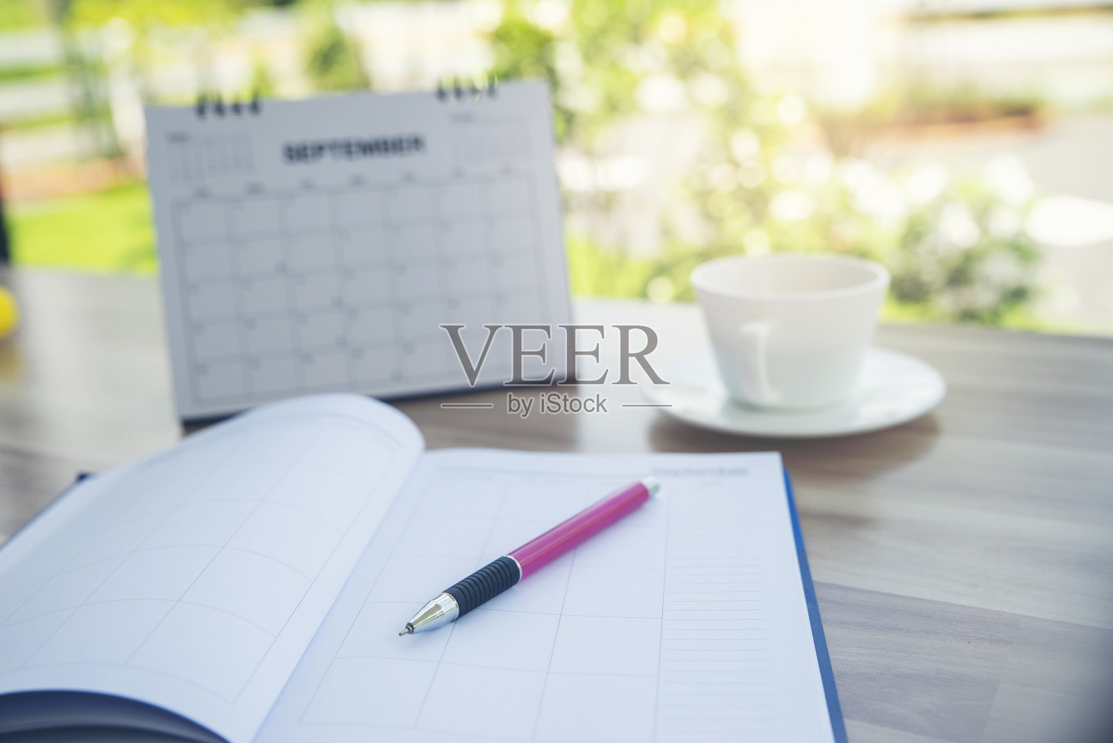 学生课桌上的日记和计划簿，准备考试。木制书桌，日历，笔记本，钢笔和一杯咖啡。书桌为学生在家工作的概念照片摄影图片