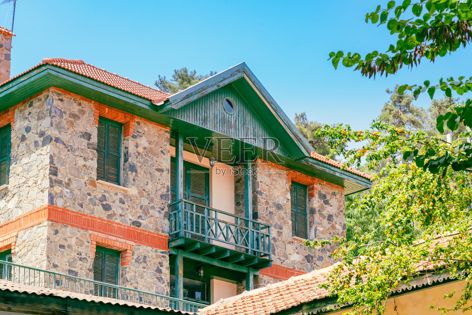 塞浦路斯古老村庄普拉特雷斯的一条阳光明媚的狭窄街道。在阳光明媚的日子里，石墙和充满活力的绿色植物。照片摄影图片