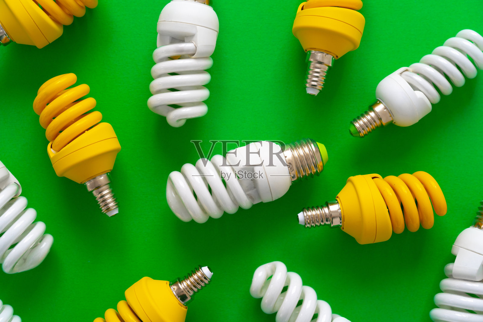 绿纸背景上的灯泡靠近照片摄影图片