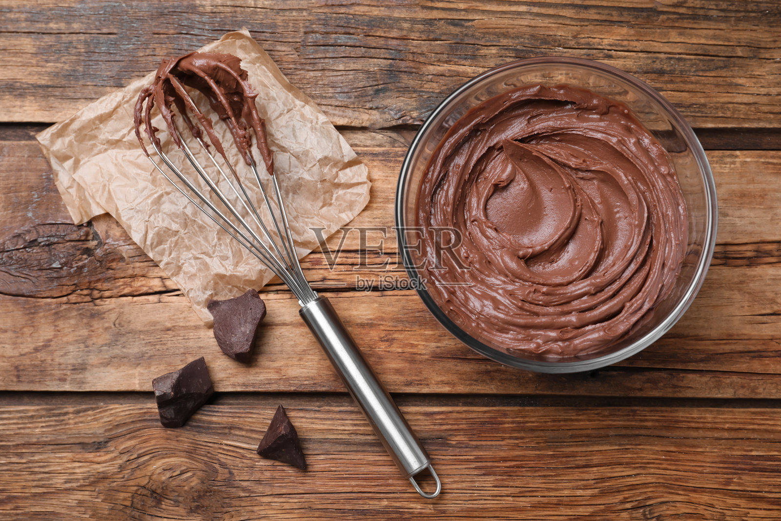 巧克力奶油和气球打蛋器放在木桌上，平躺着照片摄影图片