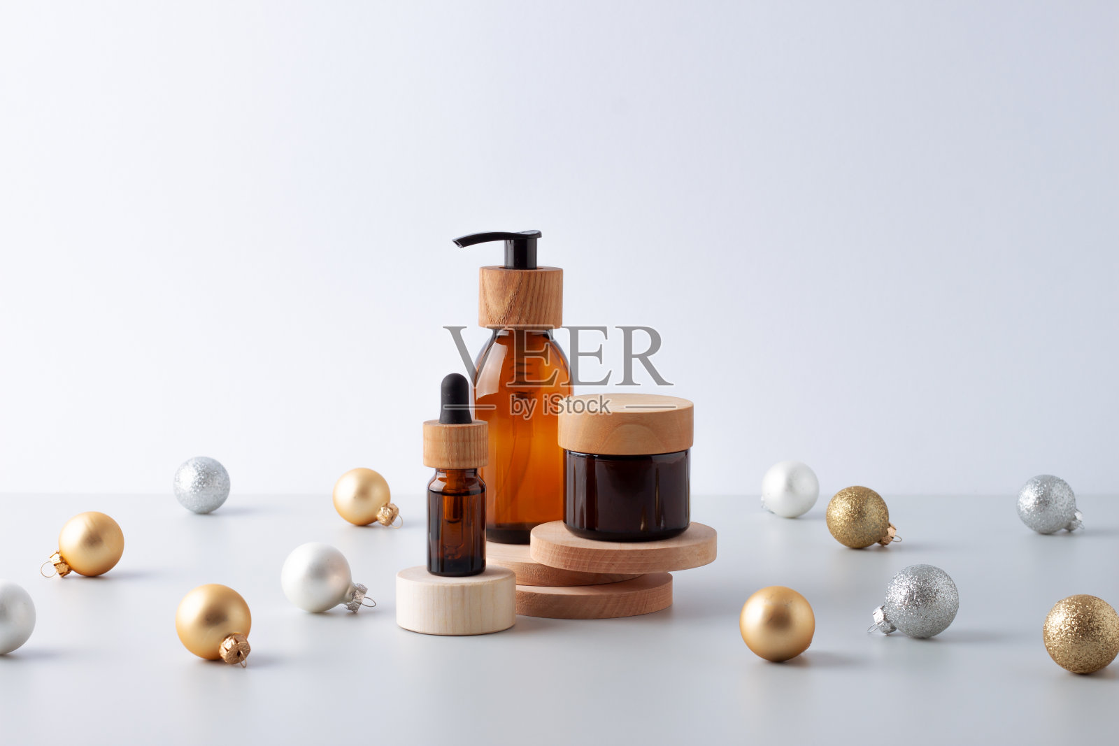 圣诞化妆产品展示。天然护肤产品在领奖台与圣诞球。关闭，复制空间照片摄影图片