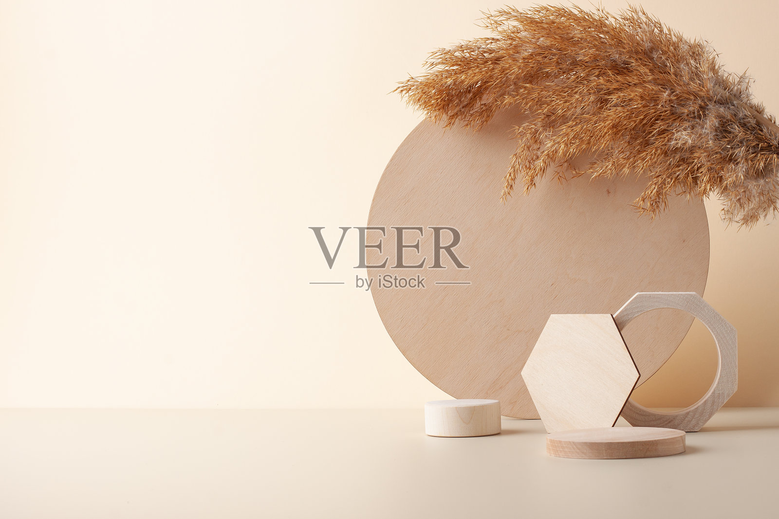 化妆品背景与木材和潘帕斯草原上柔和的米色。化妆品展示的空橱窗。照片摄影图片