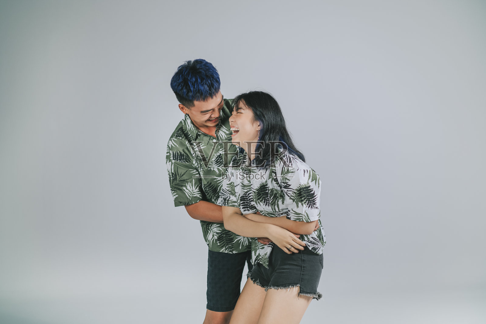 亚洲华人年轻夫妇夏装工作室拍摄剪出灰色的背景照片摄影图片
