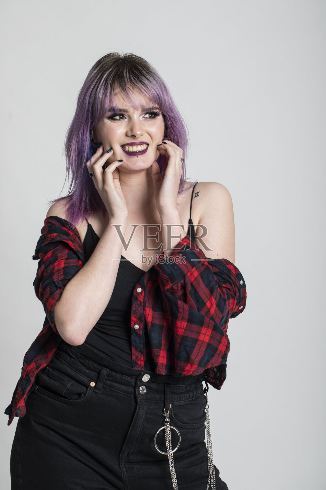 时髦的年轻女子与紫色的头发，笑，跳舞和有一个美好的时间在灰色的背景。照片摄影图片