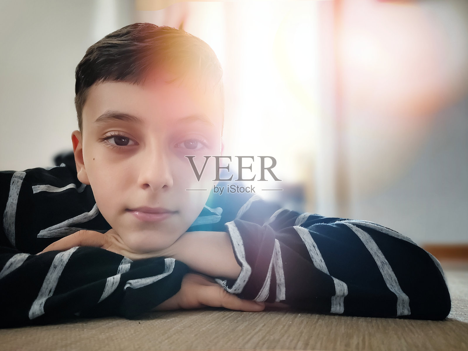 靠近男孩，他的脸靠在他的双手照片摄影图片