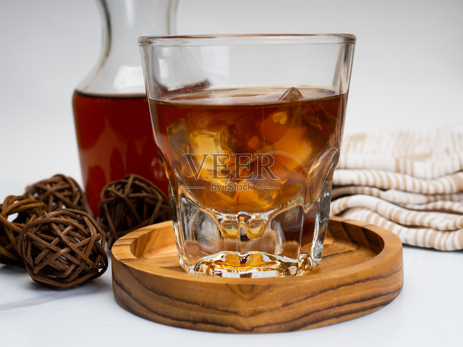 一杯冰咖啡放在一张木桌上，上面放着一个罐子照片摄影图片