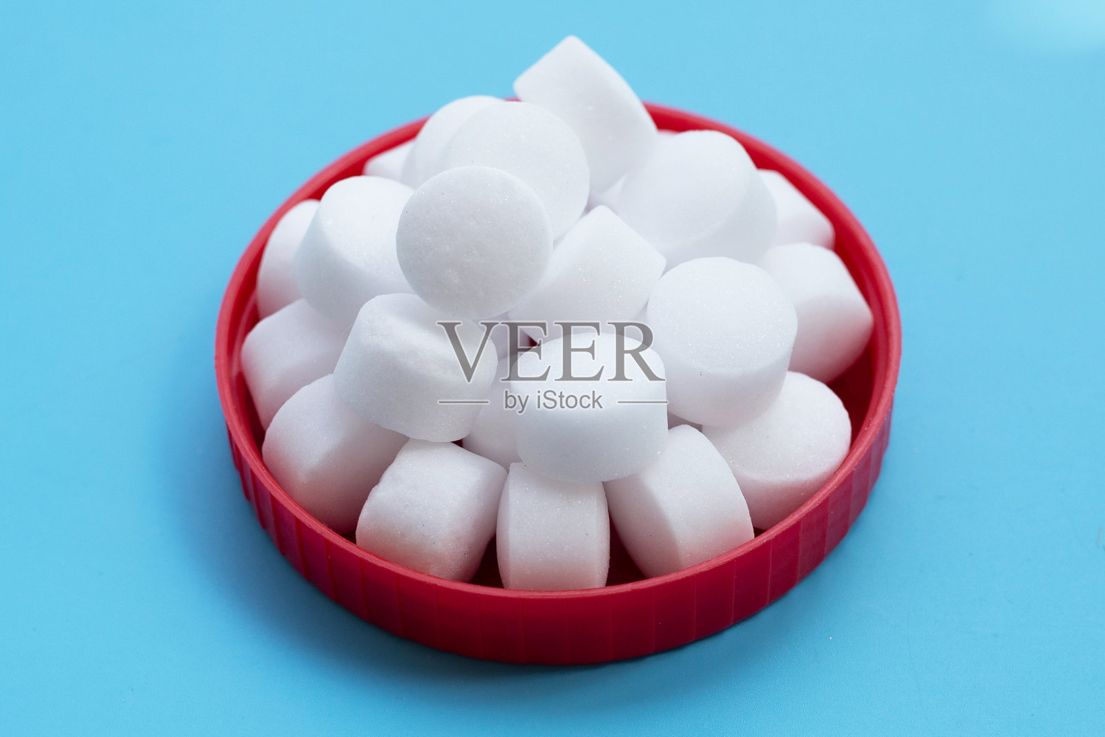 蓝色背景上的萘樟脑丸。照片摄影图片