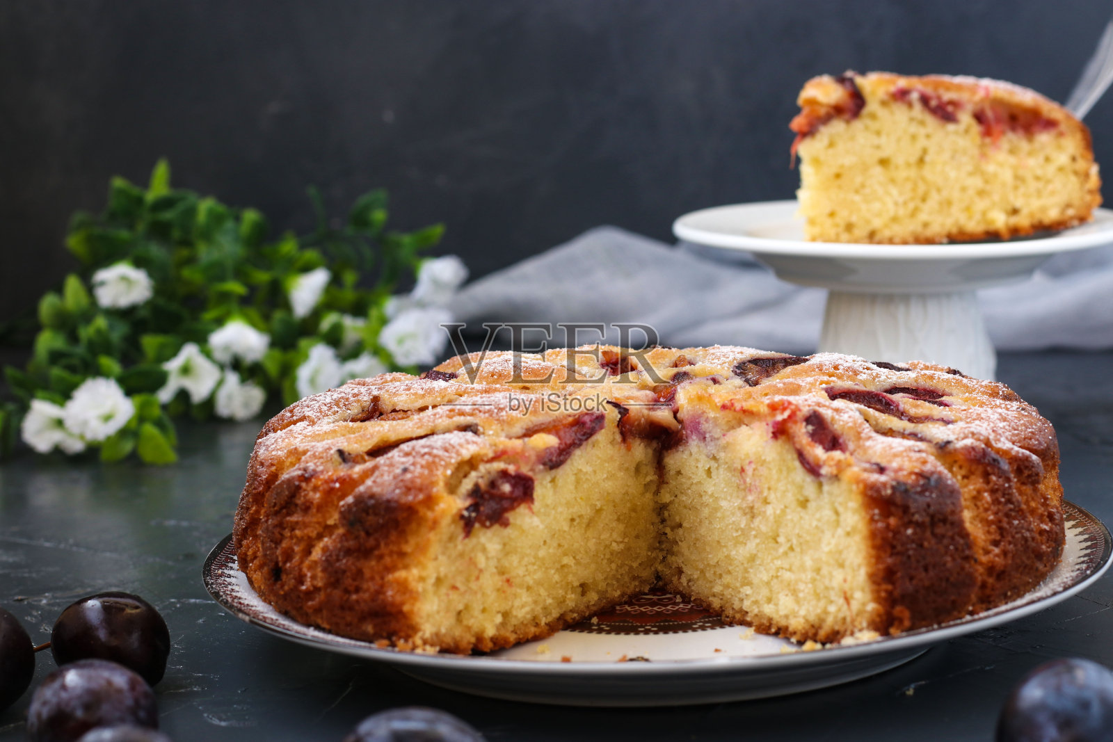 切成一块的李子派放在一个盘子上，背景是黑色的，背景是一块李子派照片摄影图片