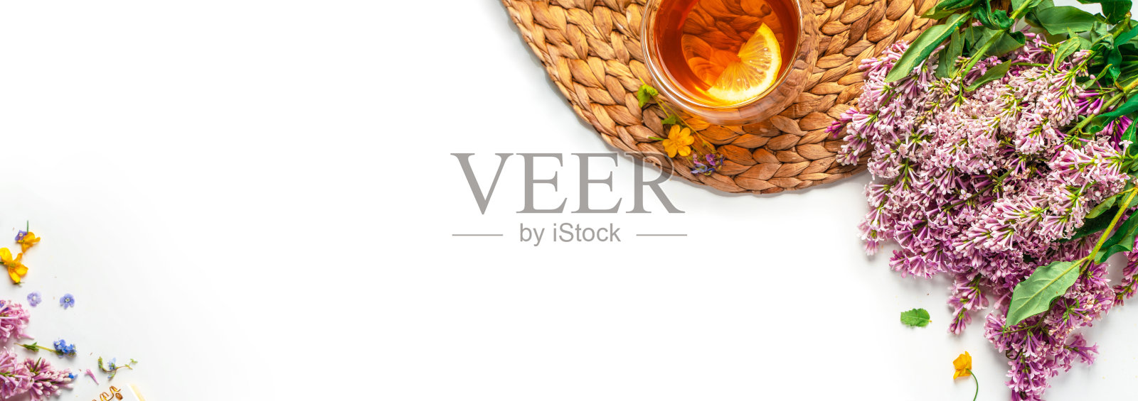 一杯柠檬丁香茶。温馨浪漫的花卉背景与拷贝空间。平的。照片摄影图片