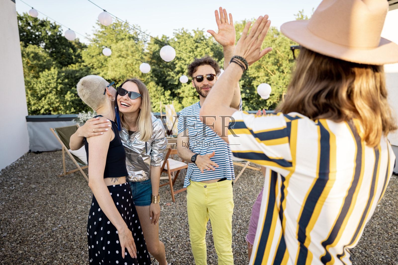 年轻时尚的朋友们在户外聚会上互相问候照片摄影图片