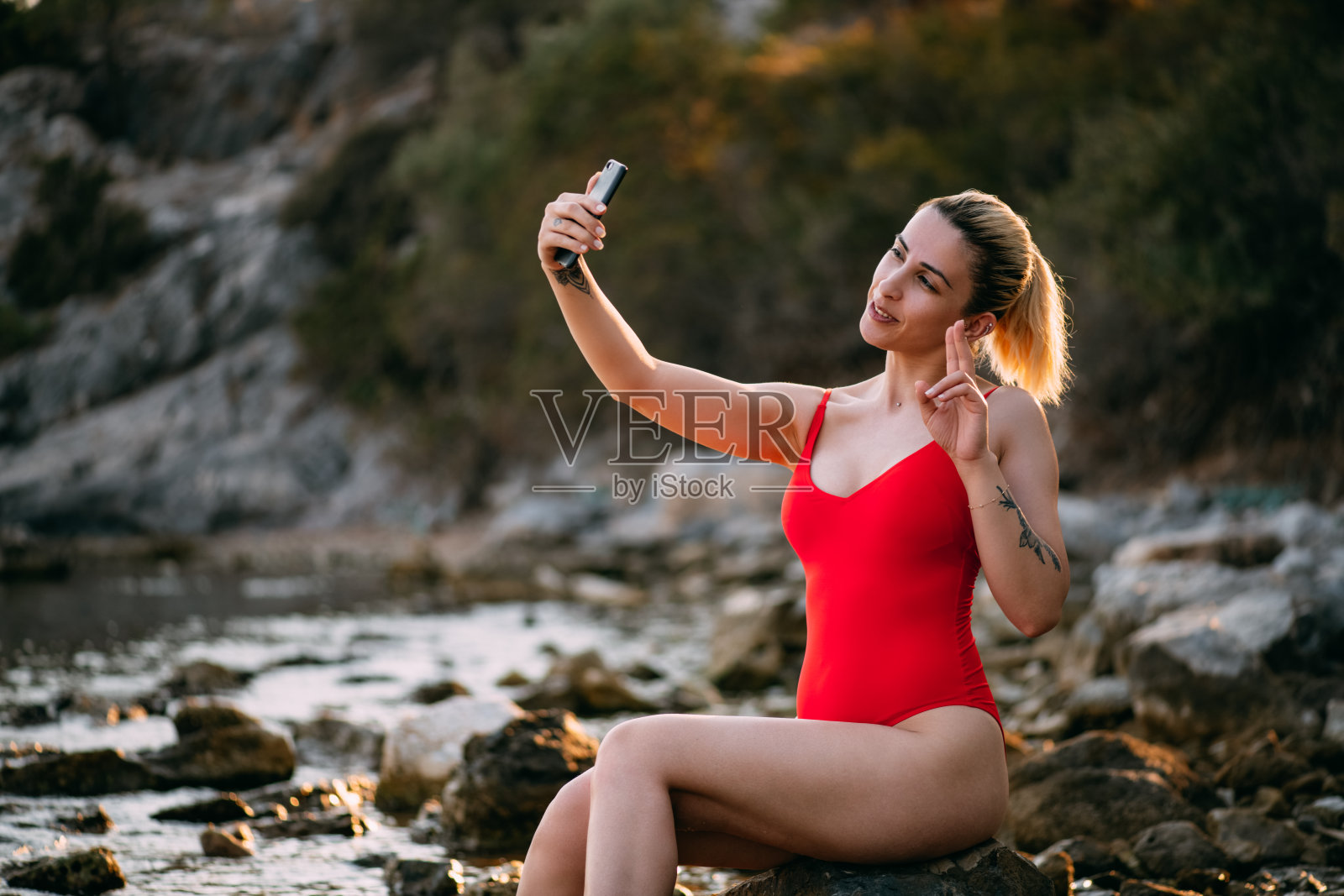 穿着红色泳衣的女人在沙滩上自拍照片摄影图片