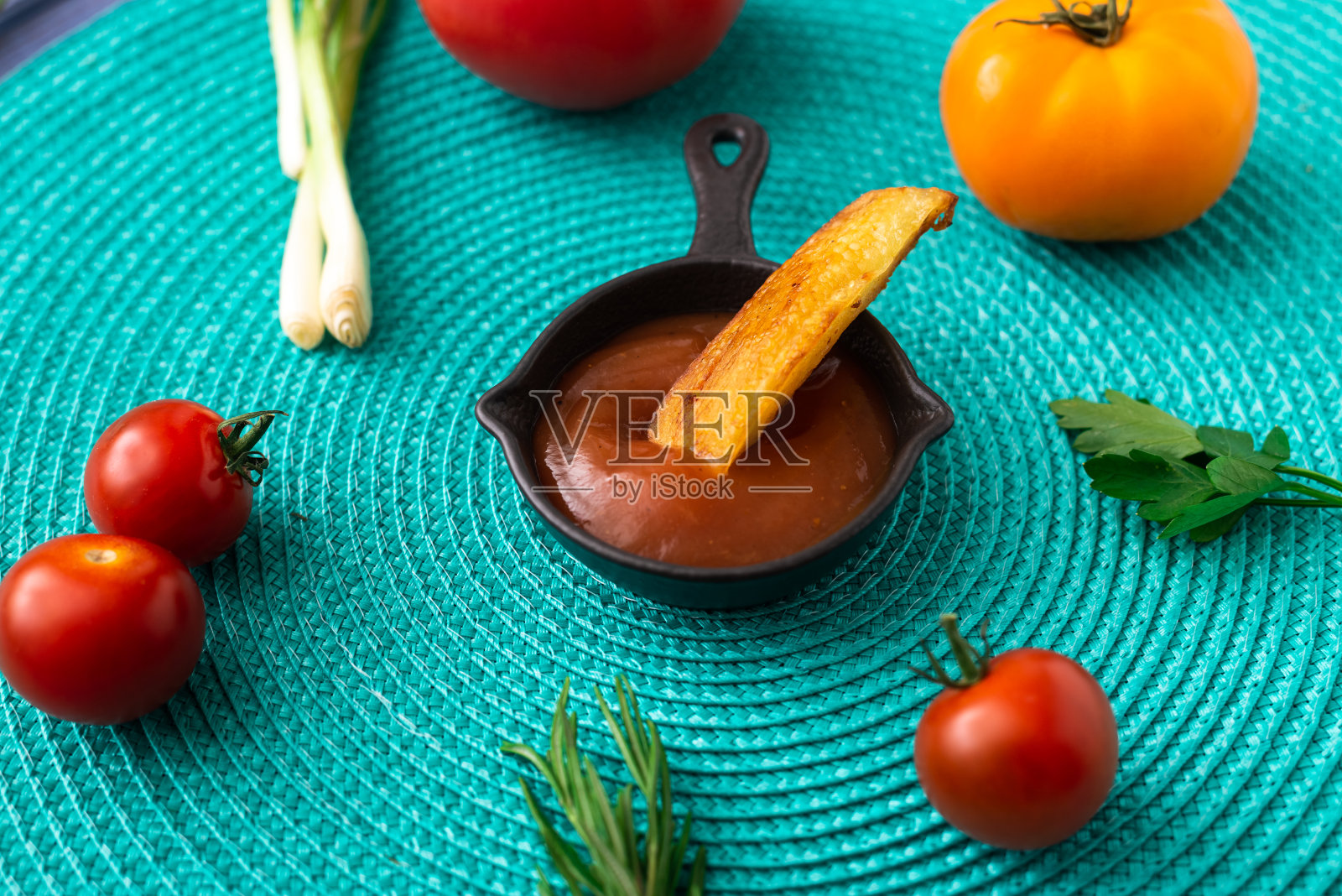 炸土豆蘸番茄酱，背景是绿松石色。附近有各种各样的蔬菜——西红柿、香草。照片摄影图片