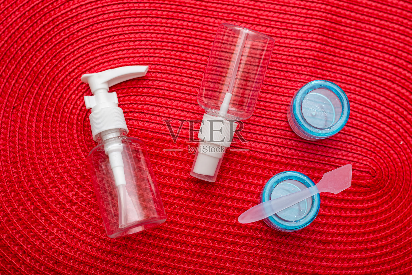 一套塑料容器，红色背景上用于航空旅行的容器。照片摄影图片