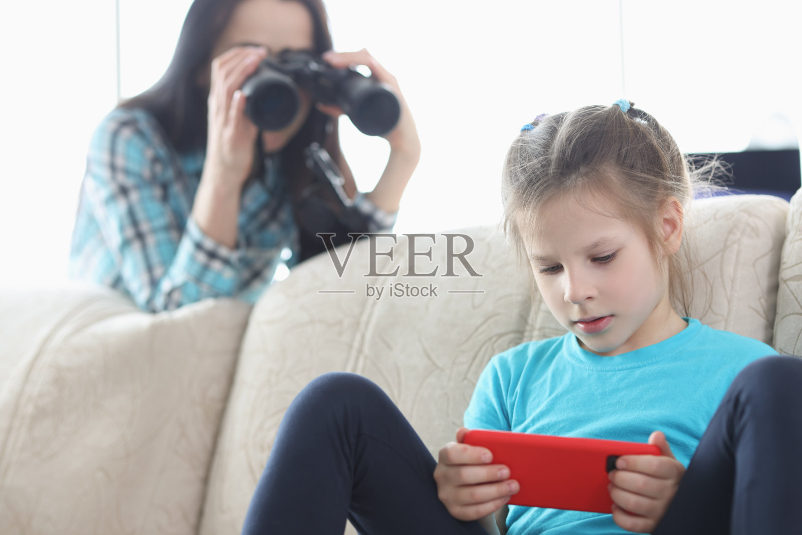 妈妈用望远镜控制她的女儿照片摄影图片