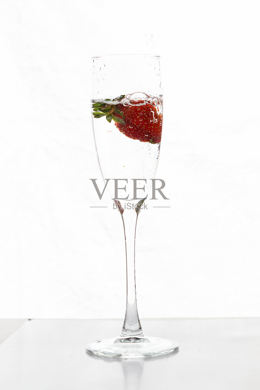 在空白的背景上用草莓填充香槟杯照片摄影图片