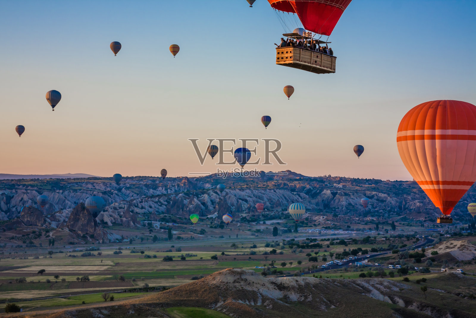 土耳其卡帕多西亚山谷上空的热气球。Goreme气球节。美丽的热气球在日出时起飞。蓝天里的热气球照片摄影图片