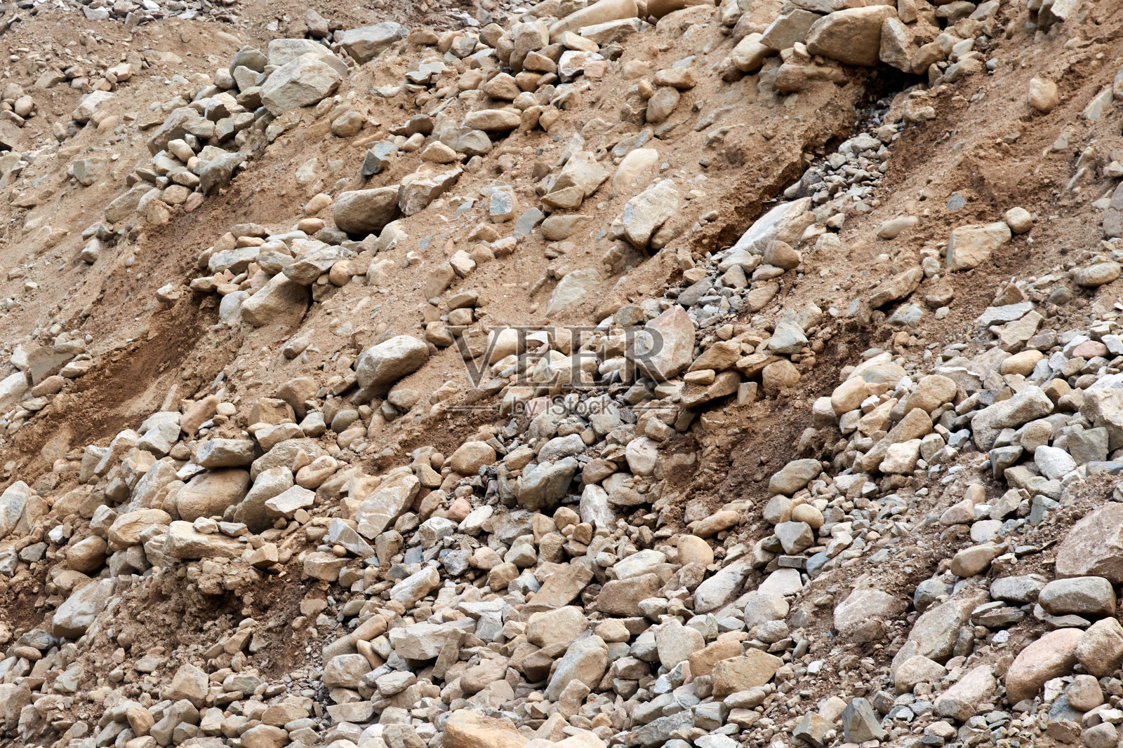 巨石，卵石和沙子从山脚下的河流照片摄影图片