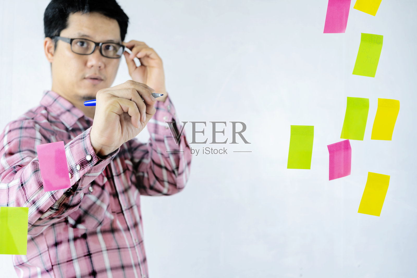 亚洲商人正在玻璃墙上分享他们的想法。照片摄影图片