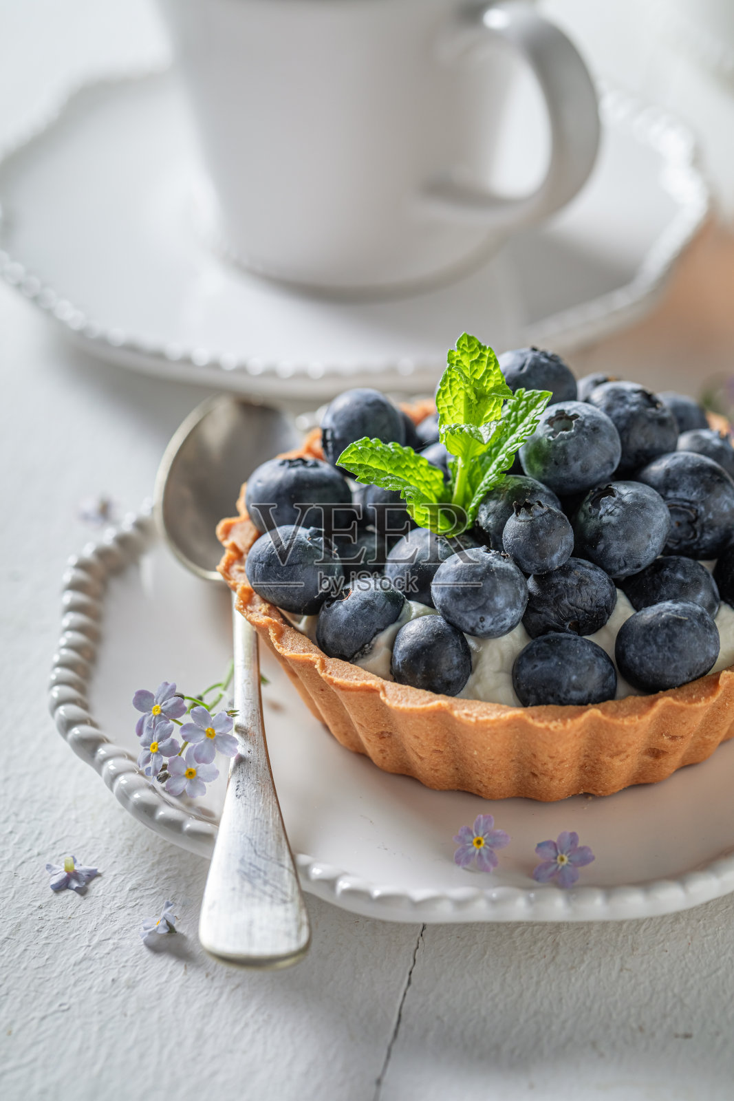 简单的夏天甜点。迷你挞配蓝莓和奶油。照片摄影图片