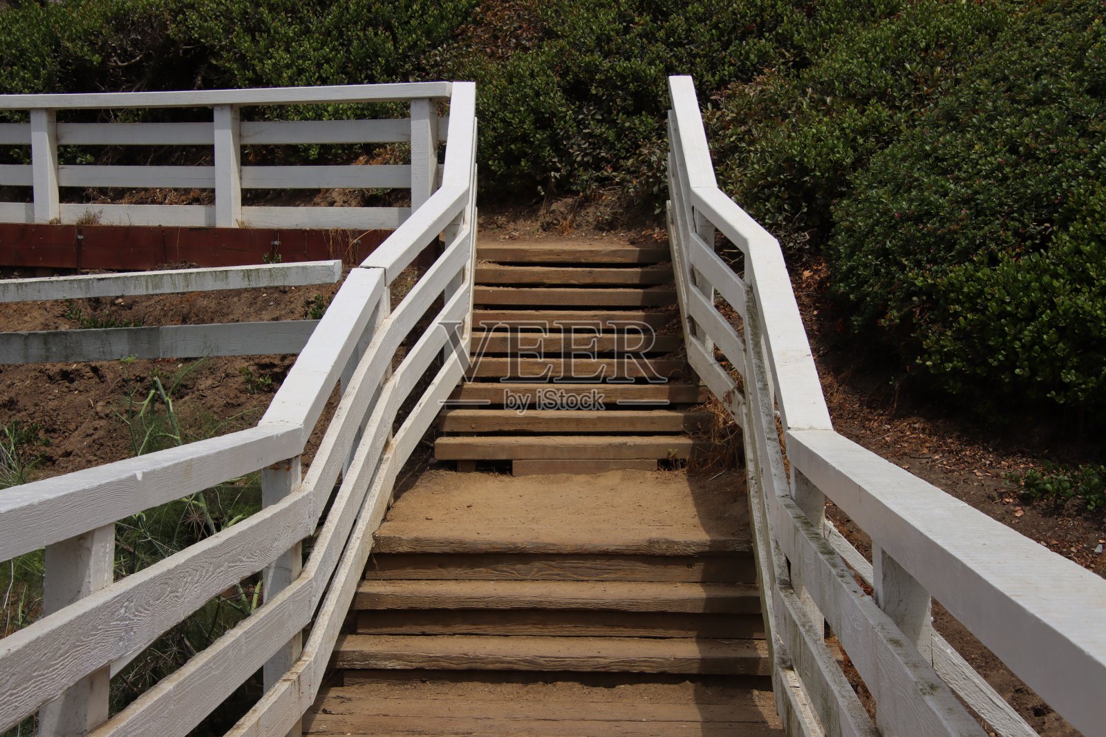 山上的徒步步道上有漆成白色的木栏杆。照片摄影图片
