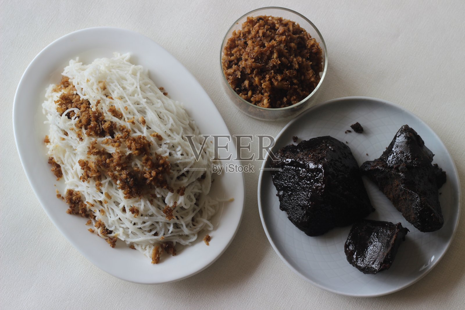 一种蒸过的米粉，里面有碎椰丝和棕榈叶。照片摄影图片