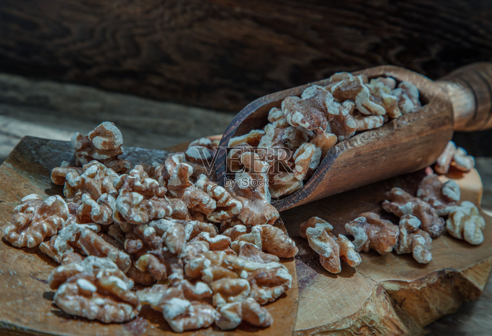 旧木桌上的一堆核桃仁。照片摄影图片