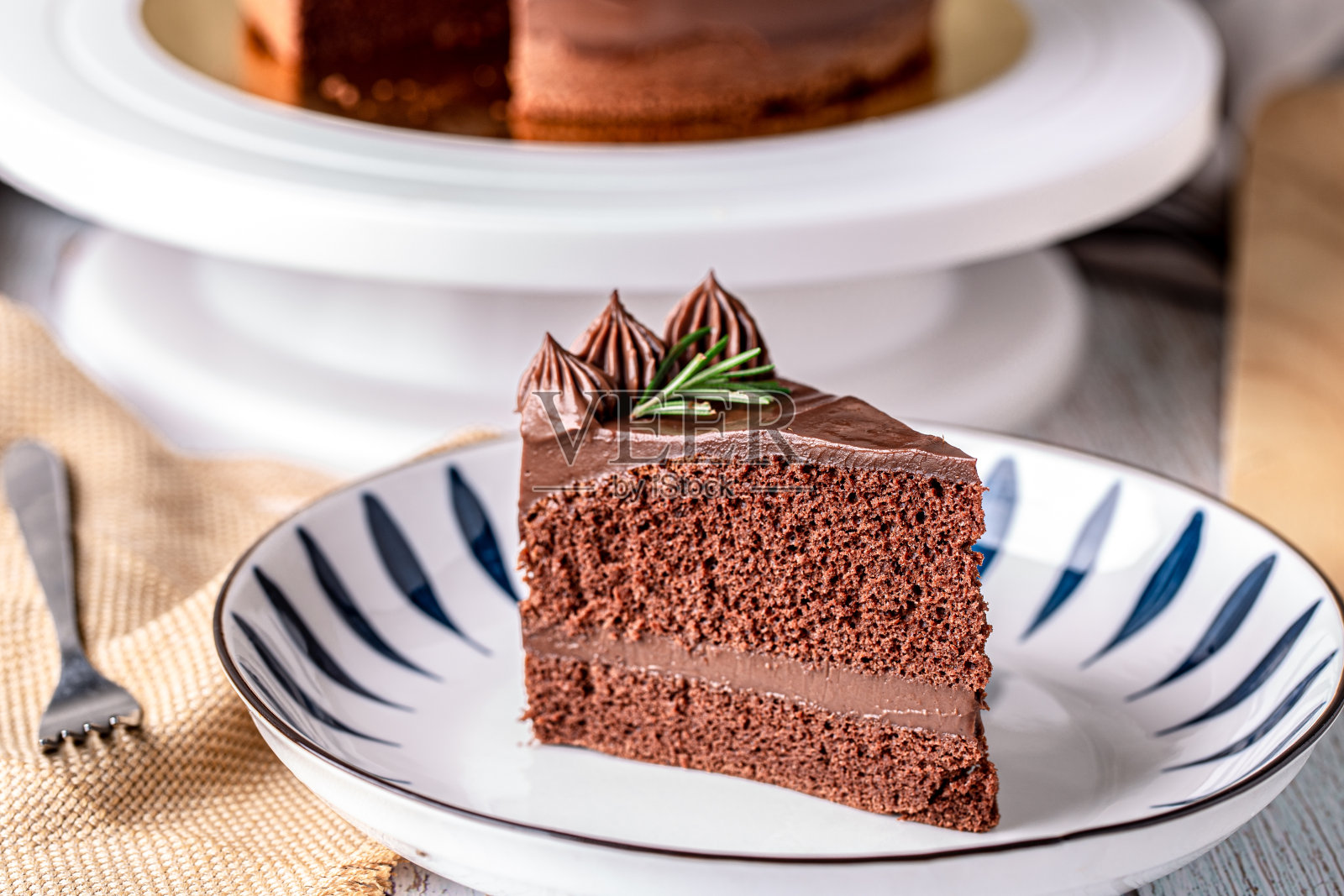 一片美味的自制巧克力软糖蛋糕，配上迷迭香。照片摄影图片