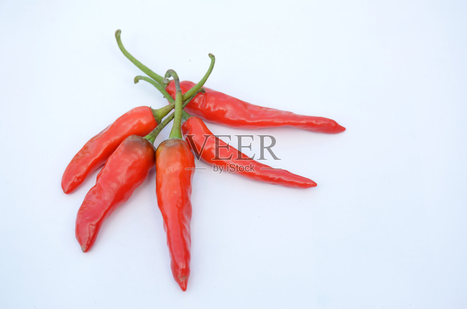 把成熟的冷的红辣椒串在白色的背景上。照片摄影图片