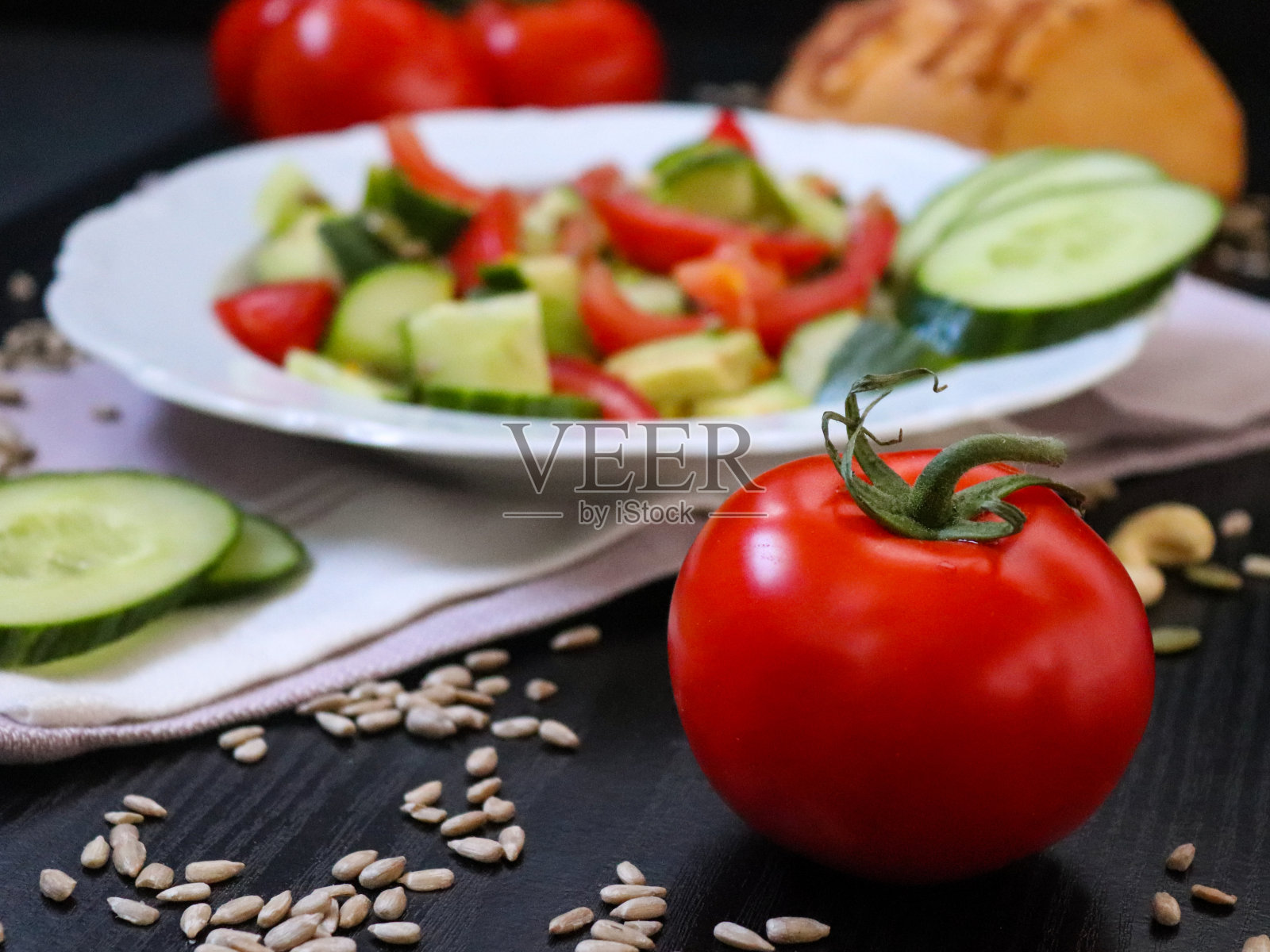 西红柿放在一盘沙拉前面照片摄影图片