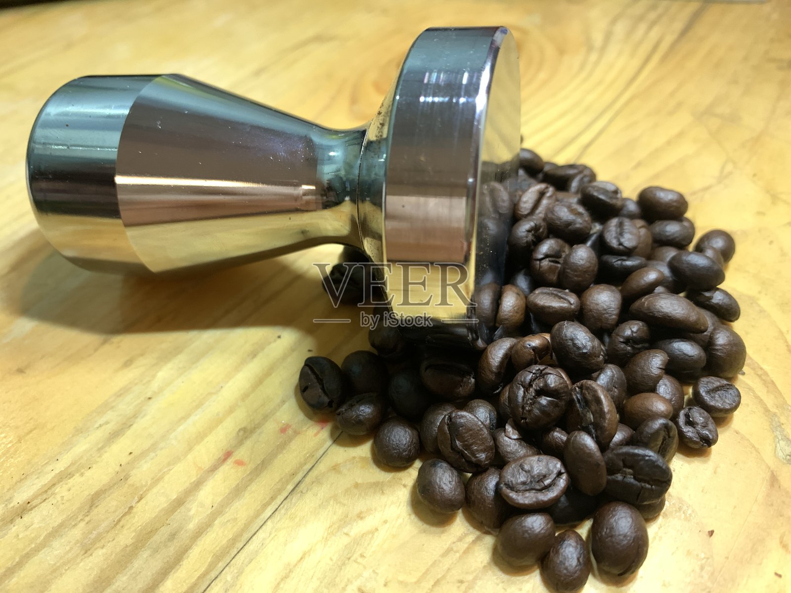 木桌上的咖啡豆和捣锤照片摄影图片