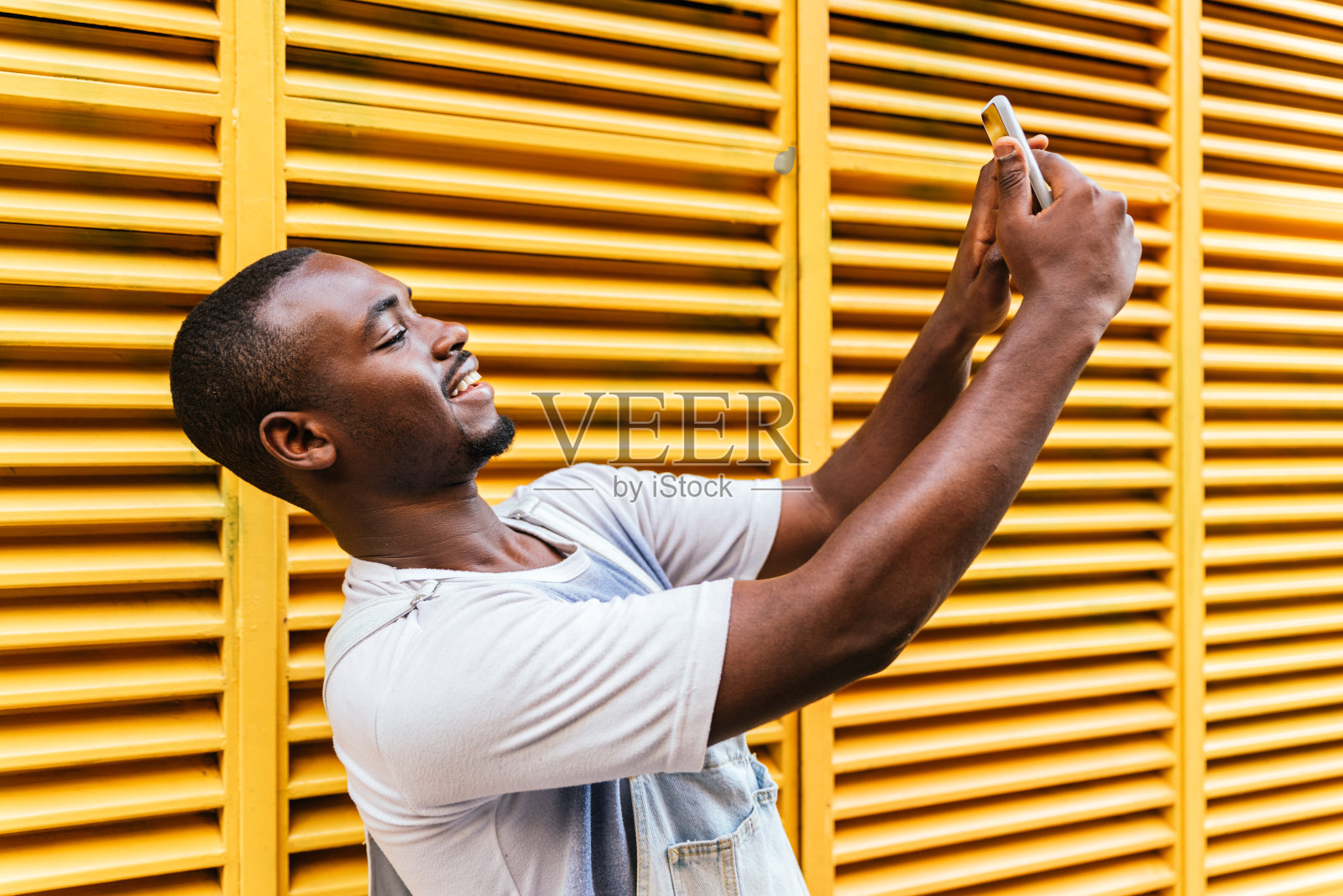 年轻的非洲裔美国人自己拍照与黄色条纹的背景照片摄影图片
