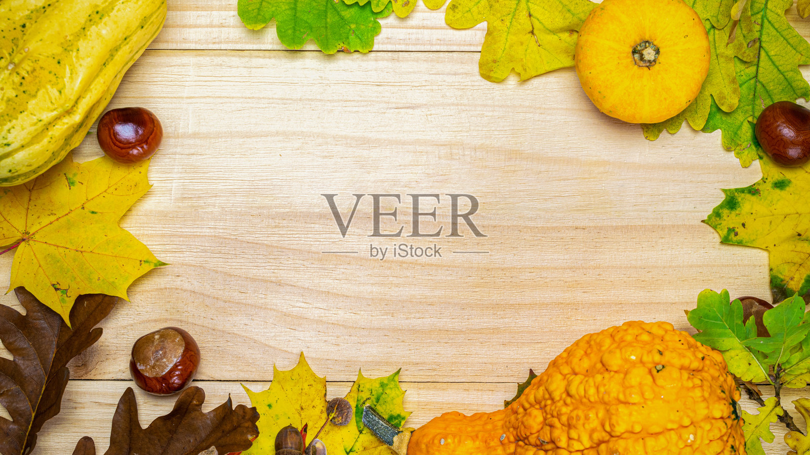 万圣节南瓜。自然收获橙色的南瓜，秋天干叶，红色浆果和橡子，栗子在木制的背景形状框架。创意俯视图平铺秋构图。照片摄影图片