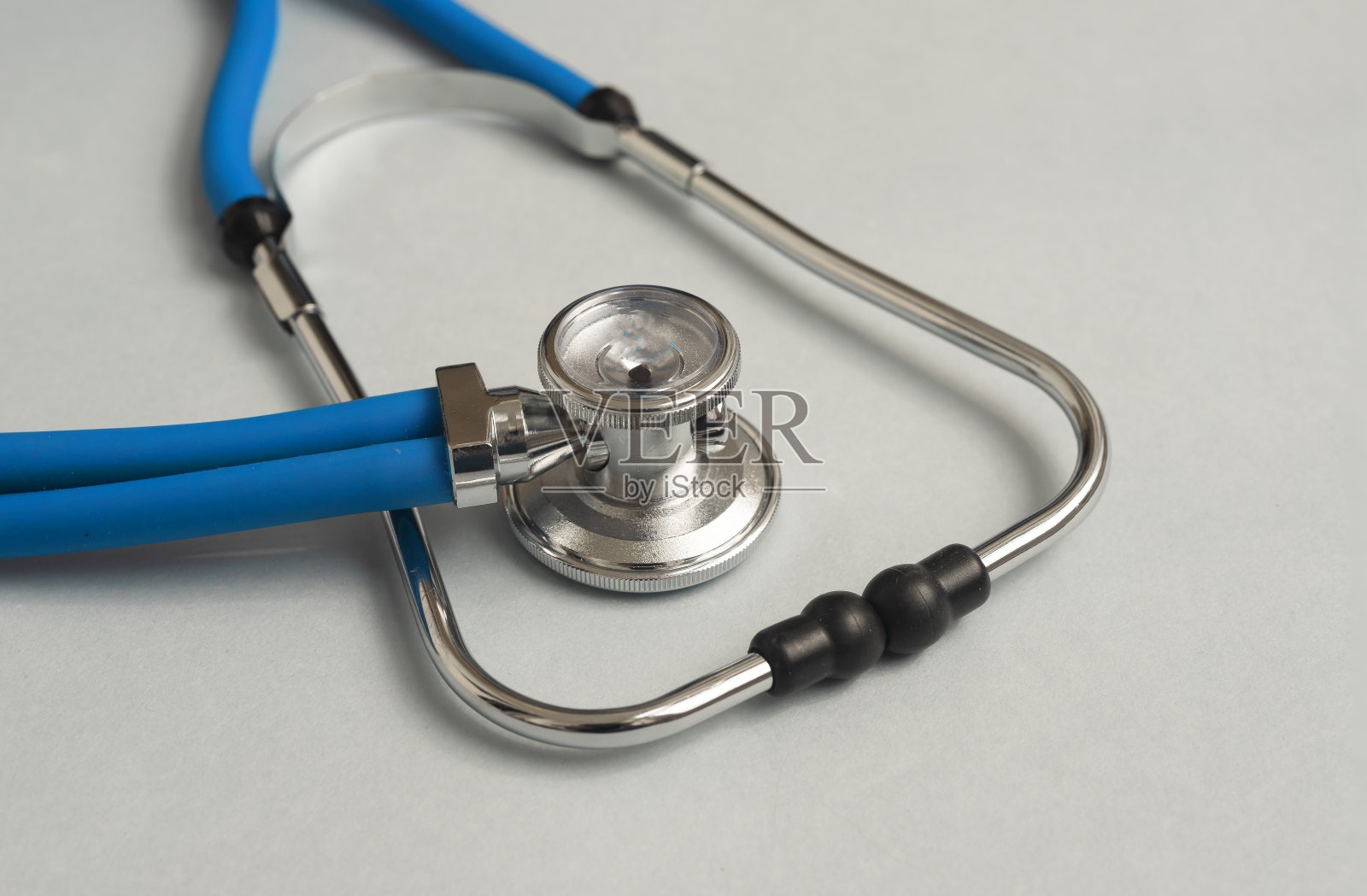 蓝色金属听诊器，灰色背景，特写照片摄影图片
