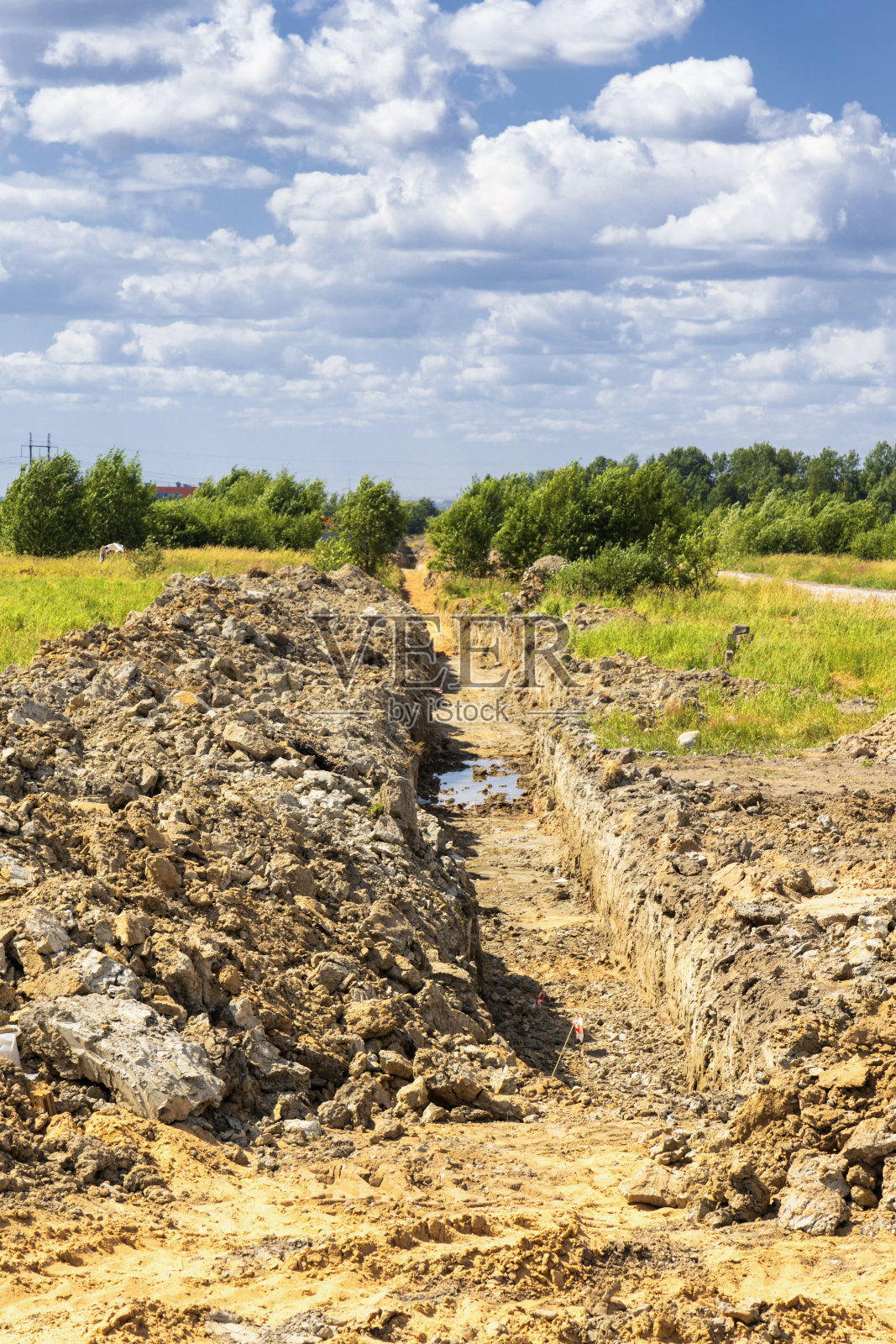 管道沟渠的边缘用成堆的挖好的土垂直定位照片摄影图片
