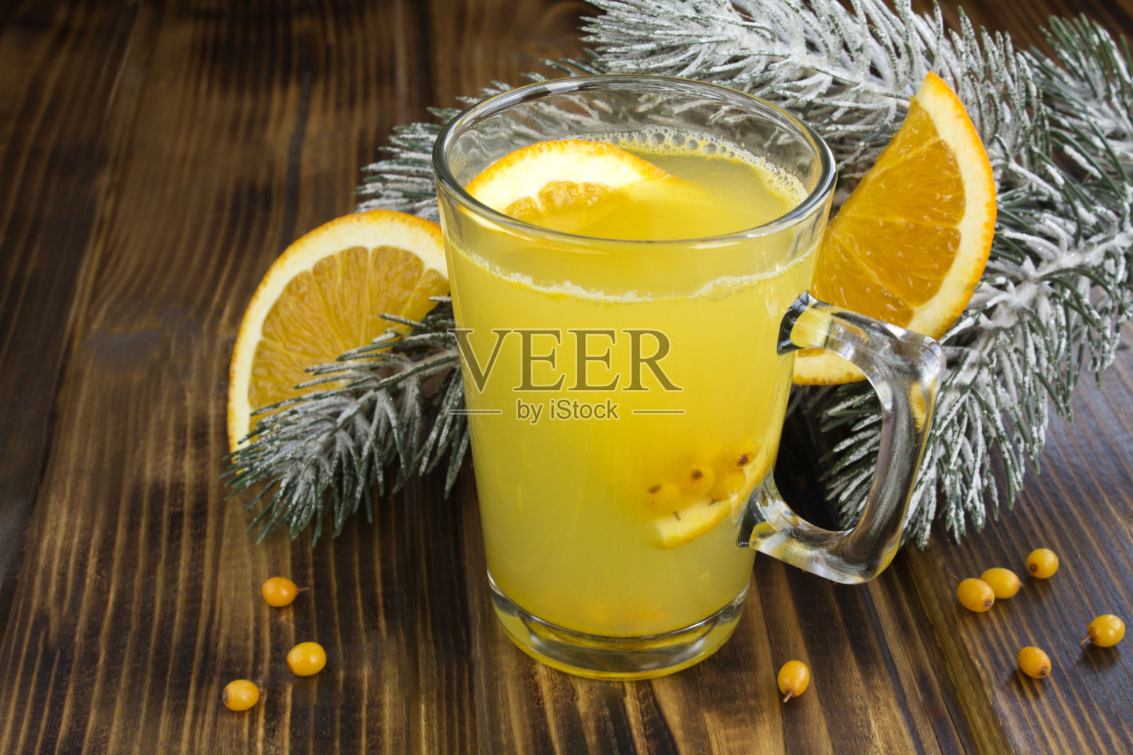 特写的热茶与沙棘和橘子在玻璃杯在木制的背景照片摄影图片