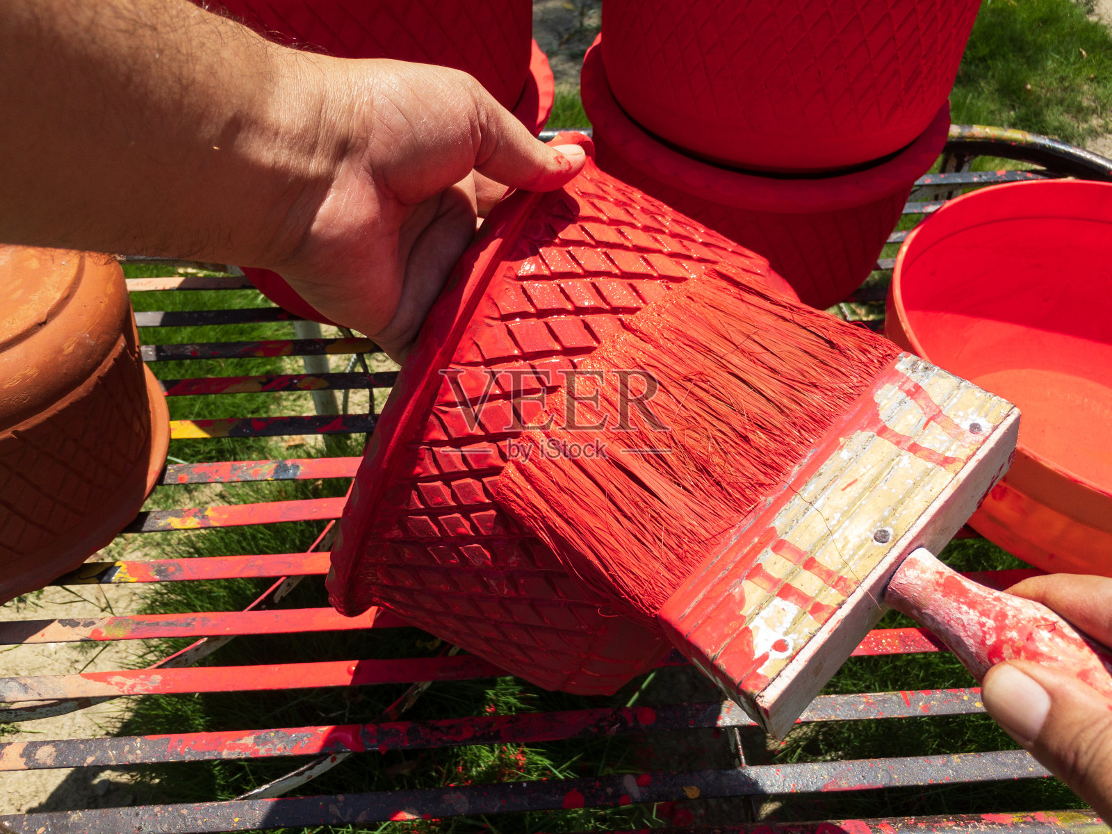 用刷子在陶土花盆上作画照片摄影图片