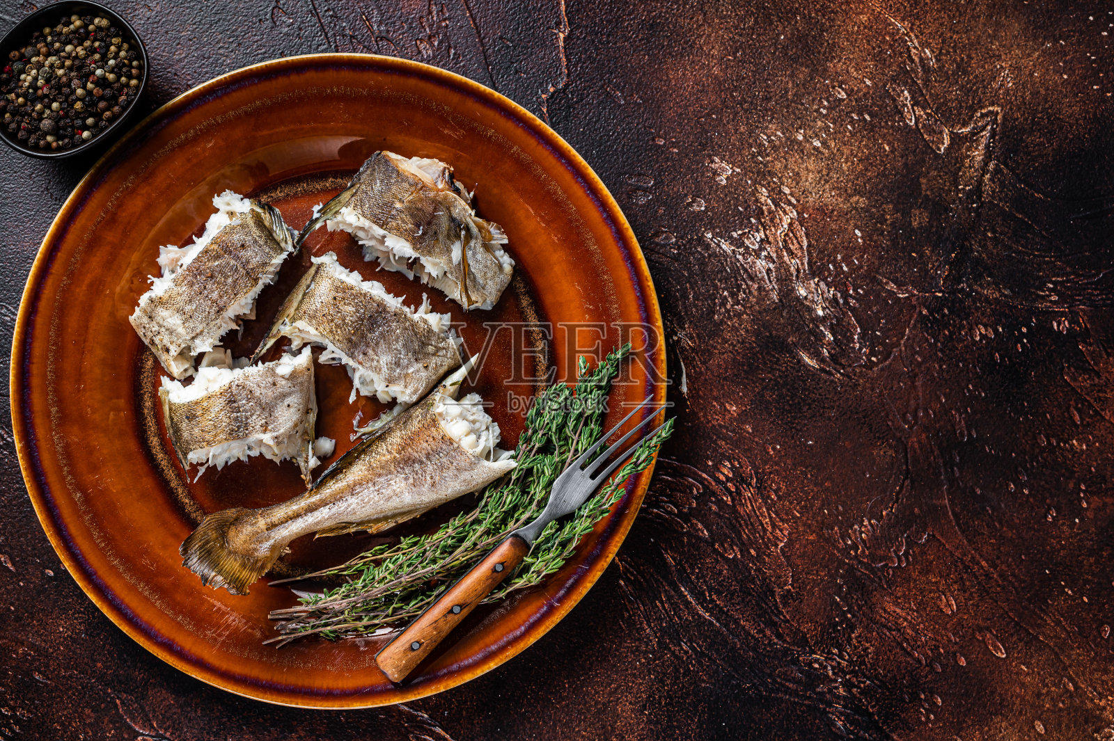 烤鳕鱼，盘子里的白鱼。深色木制背景。前视图。本空间照片摄影图片