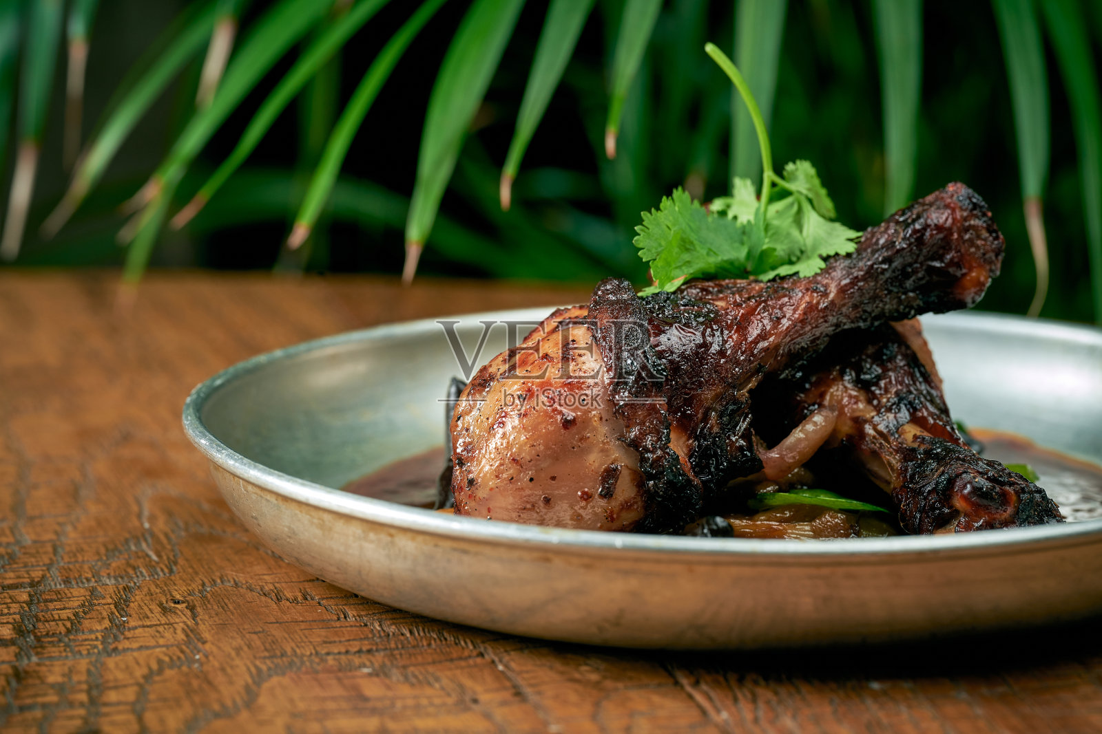 烤鸡腿配白烧烤酱、柚子黄瓜和酱汁，放在木制背景的盘子里照片摄影图片