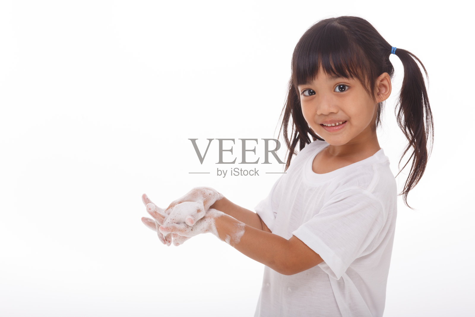 孩子正在洗手，手掌上有肥皂。在白色背景照片摄影图片