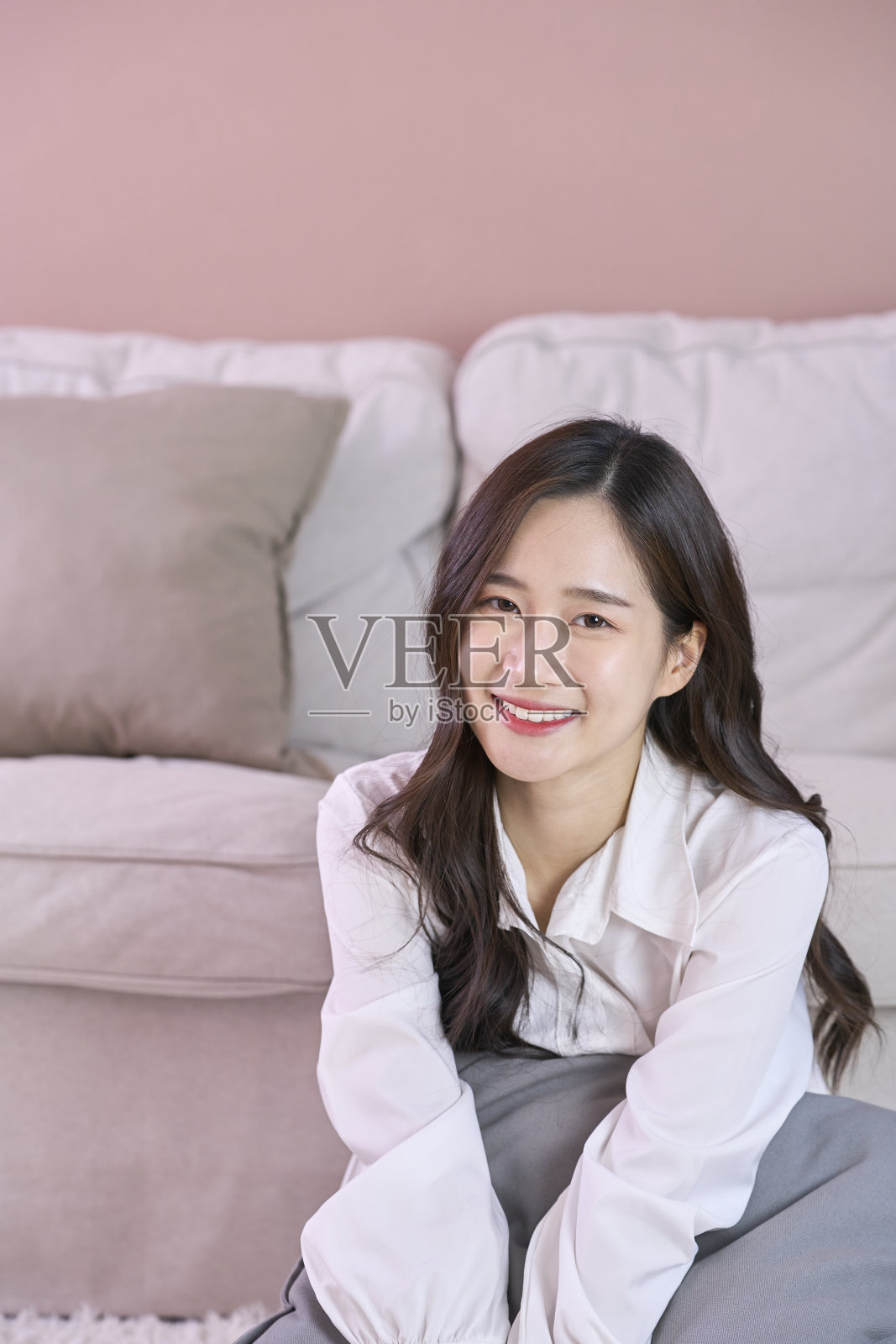 漂亮的年轻女子坐在沙发上照片摄影图片