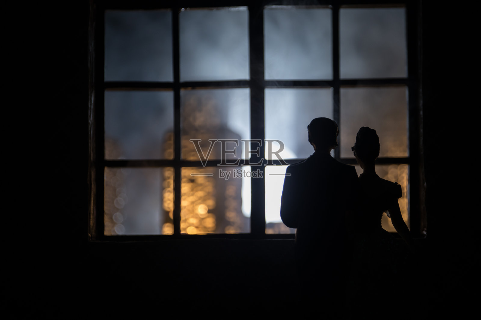 一个有家具和窗户的逼真的玩具屋客厅。一对浪漫的情侣坐在窗前。艺术品桌子装饰与手工逼真的玩偶屋。有选择性的重点。照片摄影图片