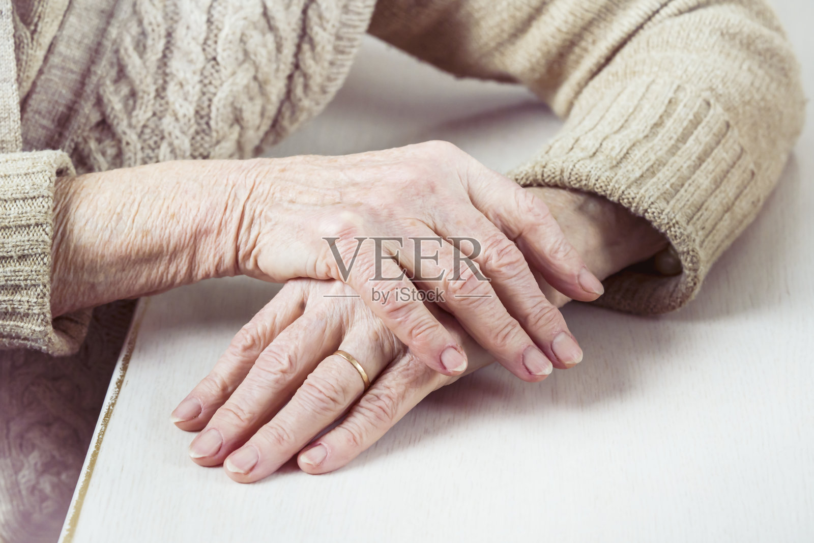 一位穿着休闲毛衣，打扮得体的老妇人的手。照片摄影图片