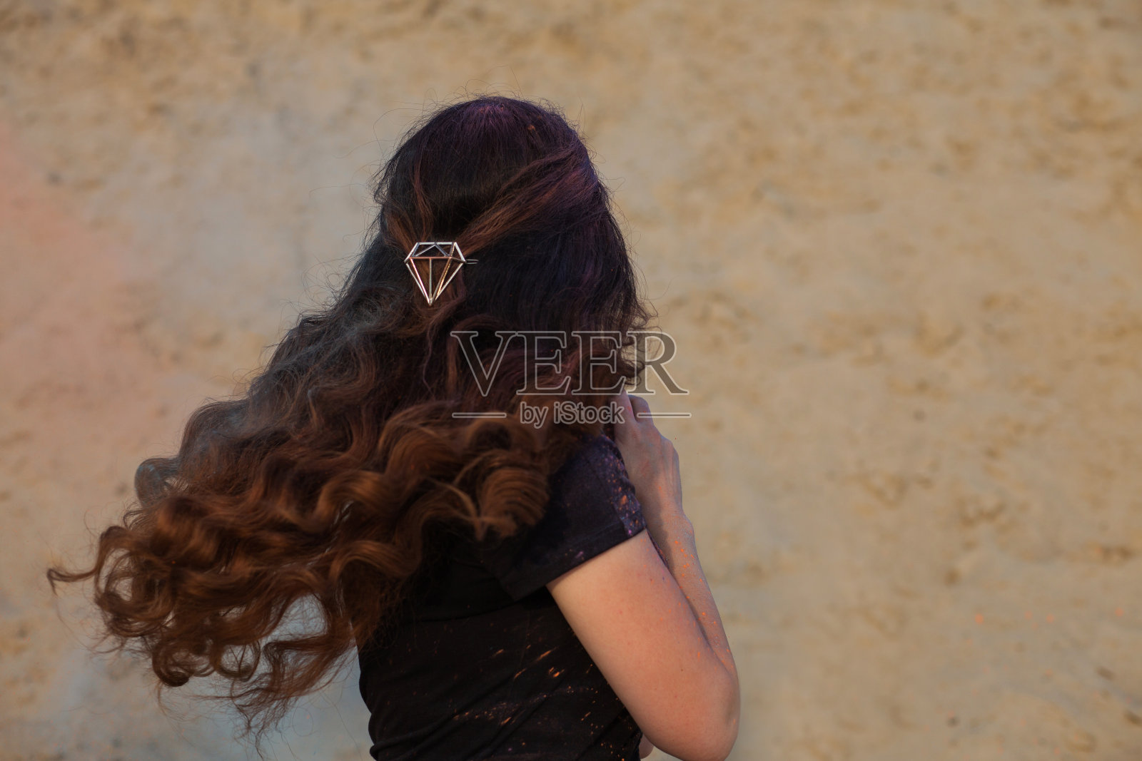 漂亮女孩的特写肖像与长飘动的头发覆盖在彩色的干颜料胡里沙漠照片摄影图片