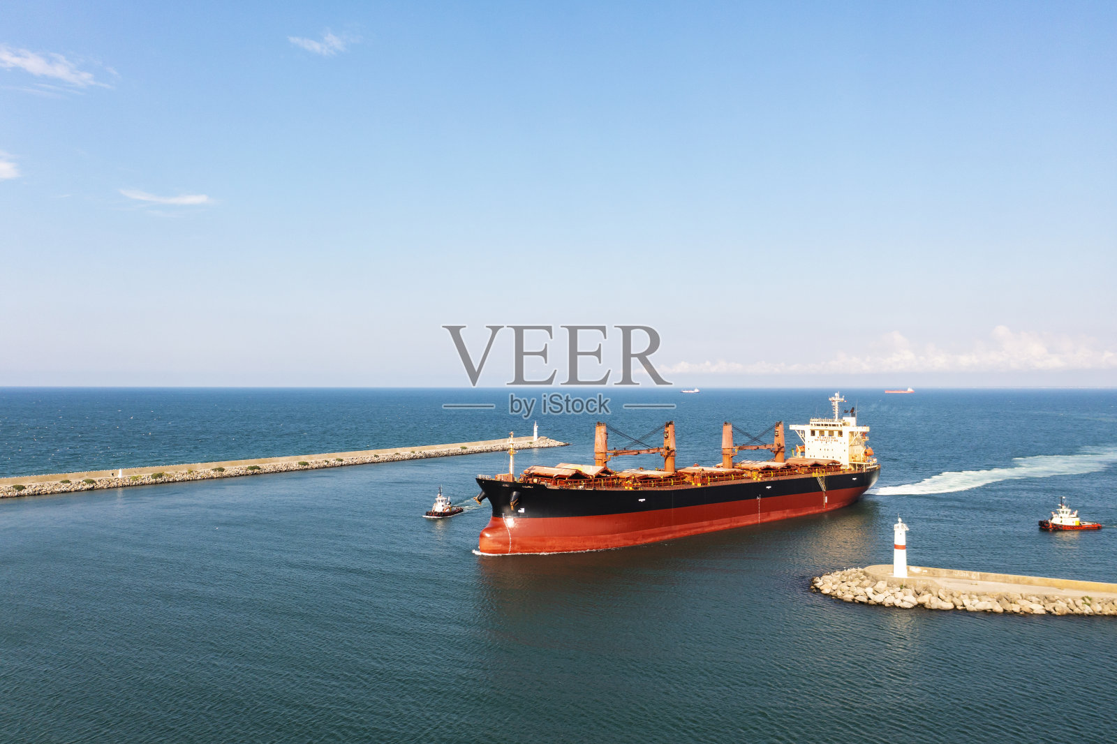 货船与拖船接近港口鸟瞰图。照片摄影图片