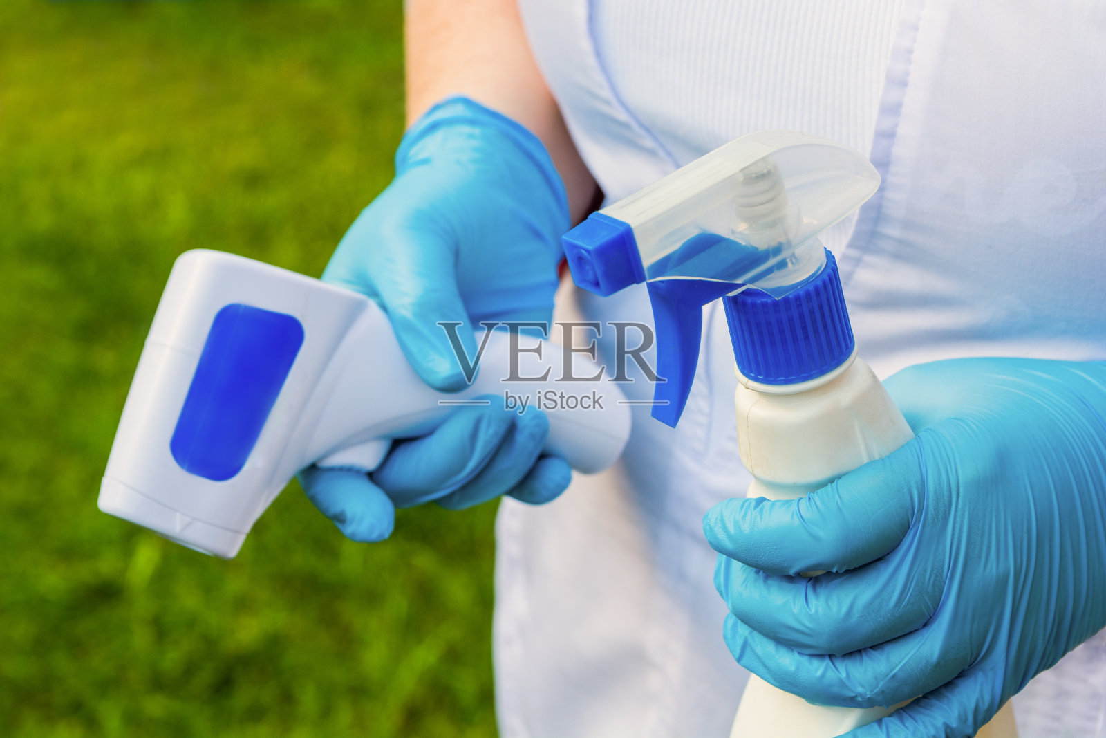 戴着医用手套的女人拿着消毒液和温度计，冠状病毒期间的卫生用品照片摄影图片