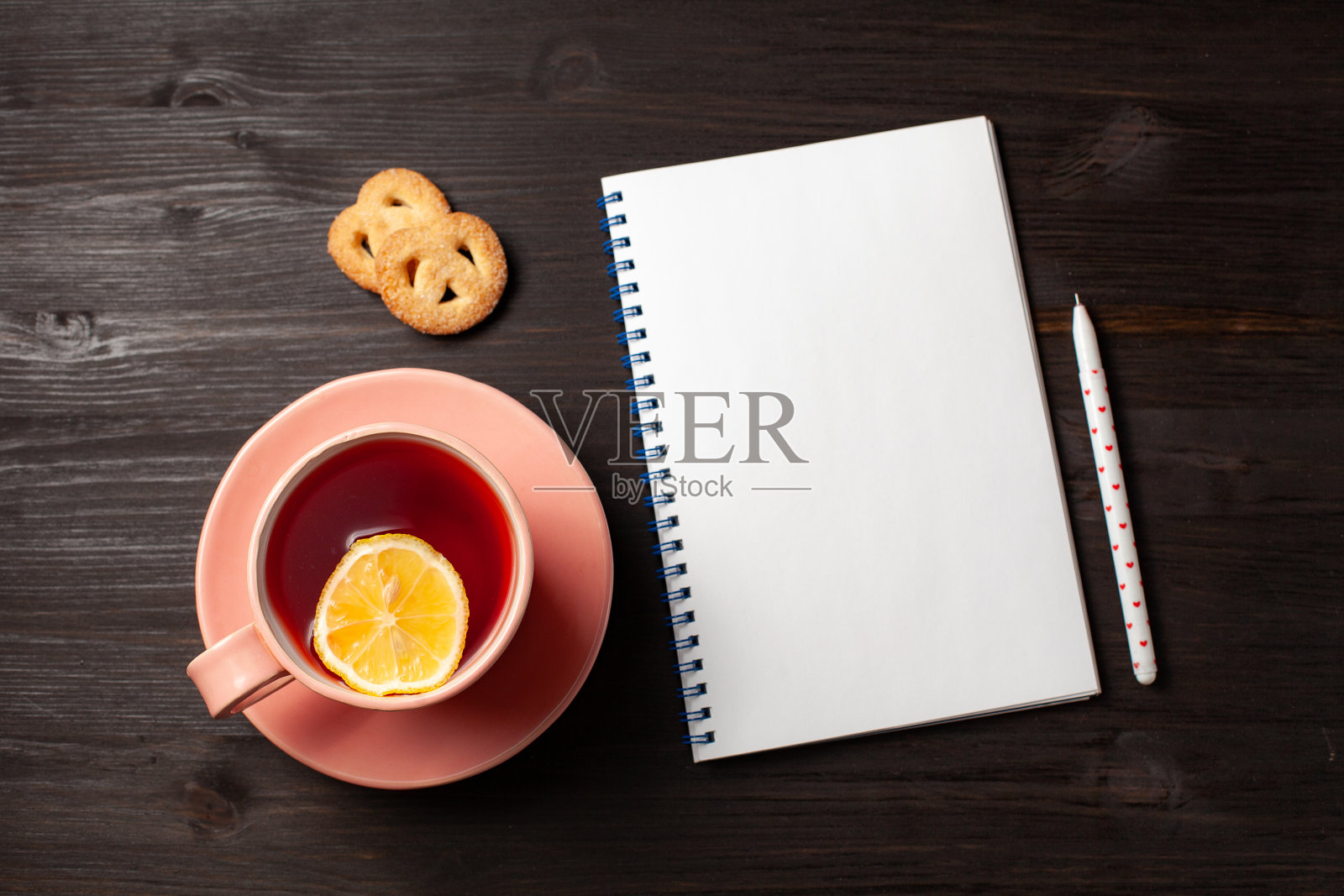 打开抄写本，一杯茶，一支笔在一个黑色的木制背景照片摄影图片
