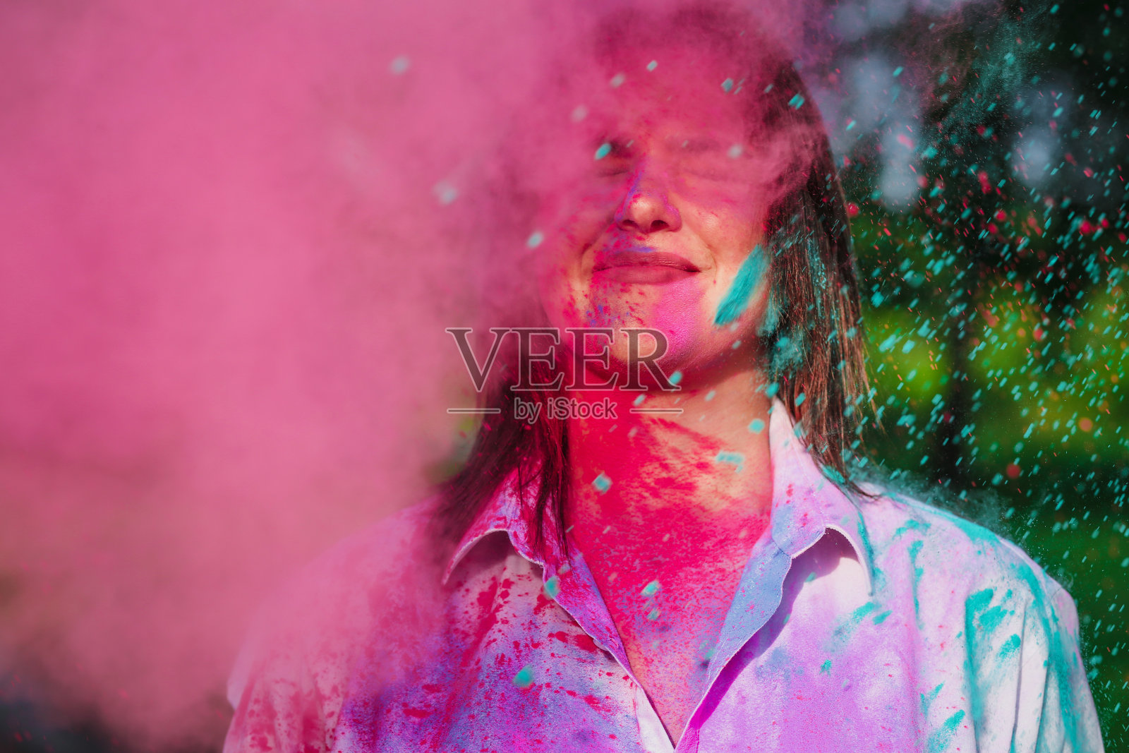 近距离拍摄的快乐的白人模特玩粉红色和绿色干油漆胡里节。Copyspace照片摄影图片