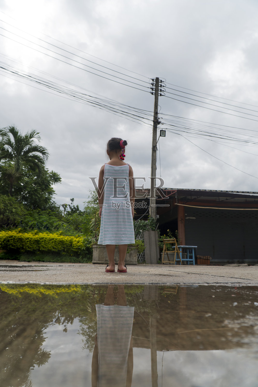 背景亚洲小女孩站在雨后看城市。照片摄影图片