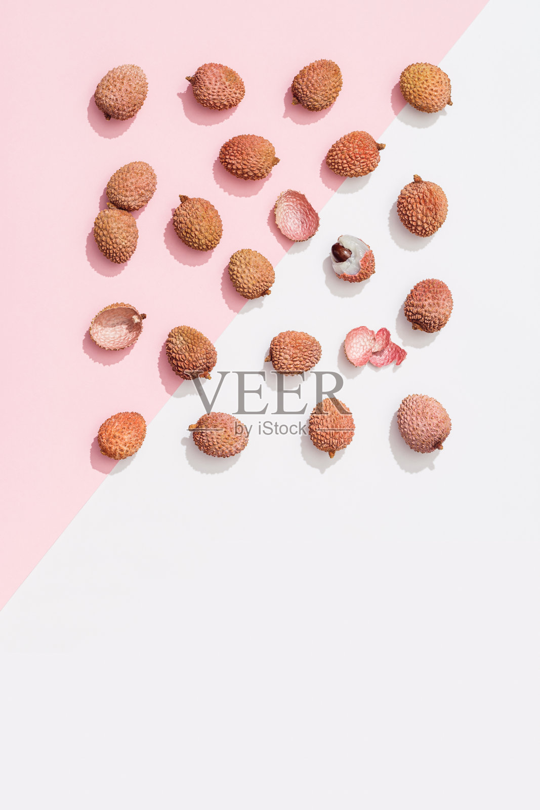 鲜荔枝果，粉白色底色。简约的水果和夏季概念。照片摄影图片